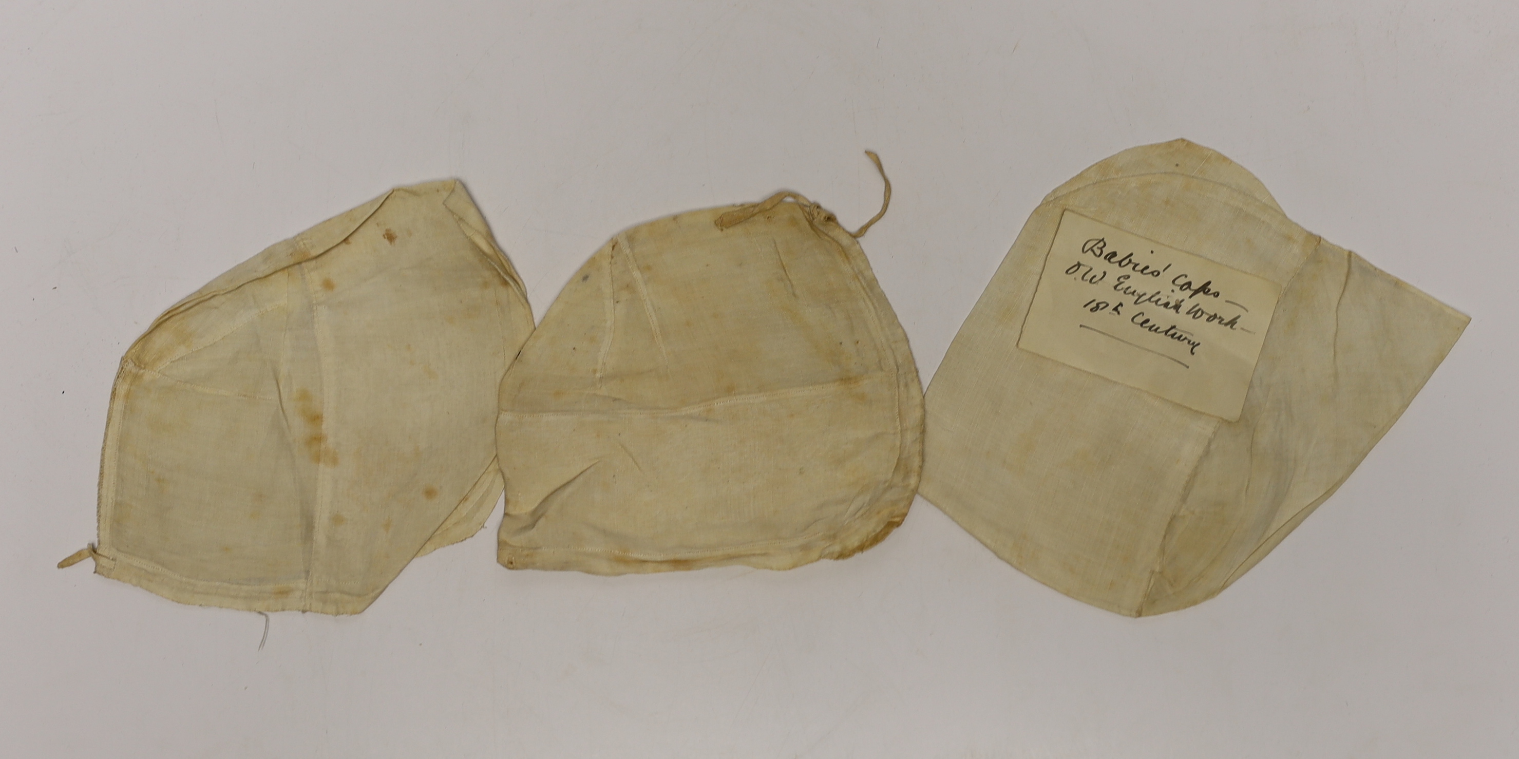 An early 18th century Hollie point insertion baby’s linen vest, three baby bonnets with Hollie point insertions and an early 18th century pair of Flemish bobbin lace lappets, a partly finished needlepoint length of lace,